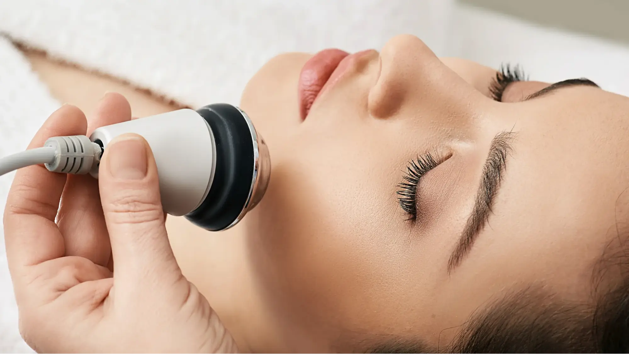 Close-up of a facial rejuvenation treatment using a handheld device on a woman's face